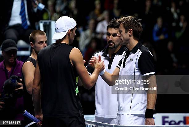 Oliver Marach of Austria and Lukasz Kubot of Poland shake hands with Nenad Zimonjic of Serbia and Daniel Nestor of Canada during their doubles match...