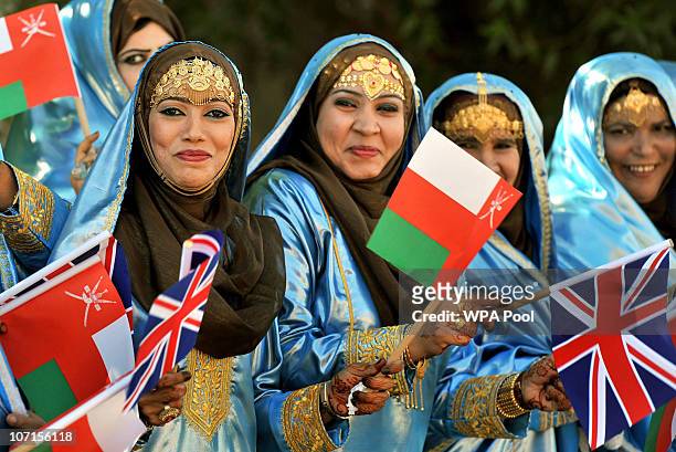 People wait for the arrival of Queen Elizabeth II and Prince Philip, Duke of Edinburgh to be officially welcomed by Sultan Qaboos bin Said at the...