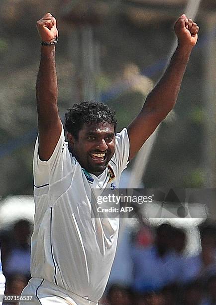 Sri Lankan cricketer Muttiah Muralitharan celebrates claming his 800th Test wicket with the dismissal of Indian cricketer Pragyan Ojha during the...