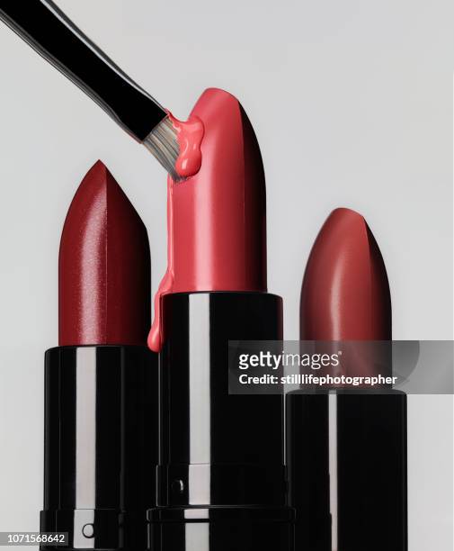 3 lipsticks in line with one brush sticking and melting the bulet - pink vanity stock pictures, royalty-free photos & images