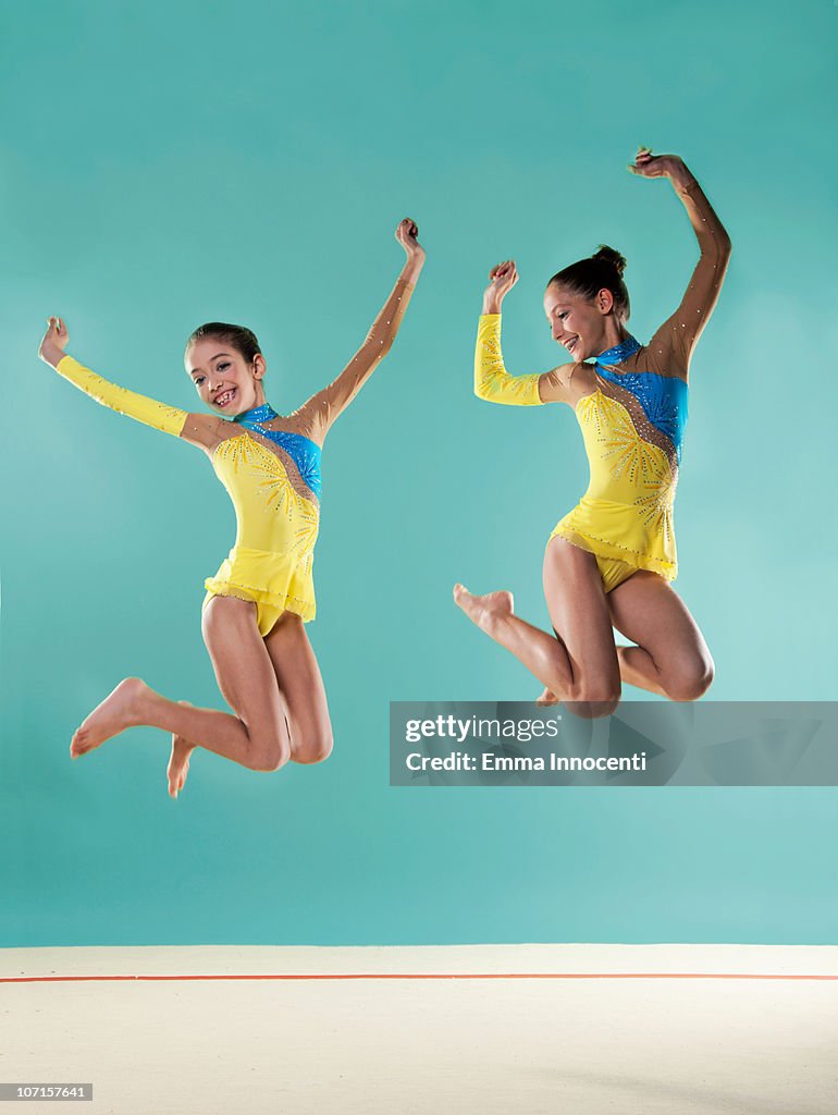  2 gymnast, jumping, mid air, happy