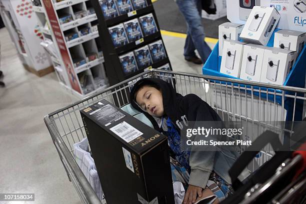 Jonathan Fernandez sleeps in his parents shopping cart after entering a Best Buy store at dawn on Black Friday, the day after Thanksgiving which...