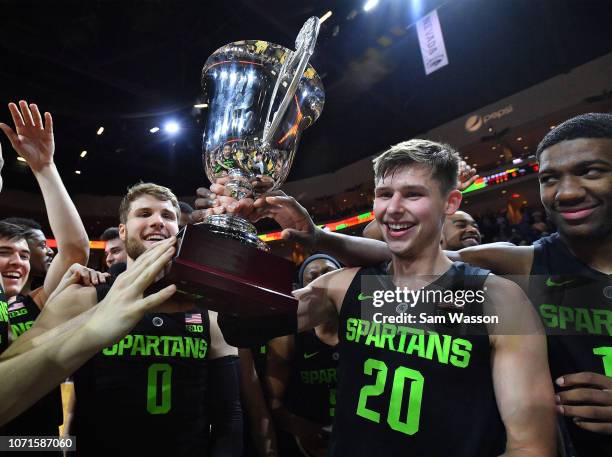 Kyle Ahrens and Matt McQuaid of the Michigan State Spartans hold up the championship trophy after winning the championship game of the 2018...