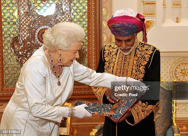 Queen Elizabeth II presents the Sultan of Oman, His Majesty Sultan Qaboos bin Said with a book, before a State Banquet at his Palace on November 26,...