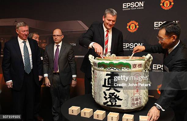 Sir Alex Ferguson and Chief Executive David Gill break the seal on a traditional barrel of sake with representatives from Epson after a press...