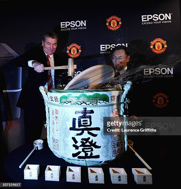 Epson Global President Mr Minoru Usui breaks a sake barrell with Manchester United Chief Executive David Gill during a Press Conference as Manchester...