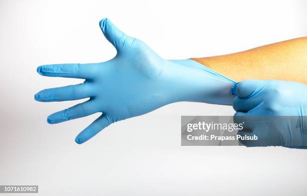 human holding variation of latex glove, rubber glove manufacturing, human hand is wearing a medical glove, glove, isolated - occupational safety and health stock-fotos und bilder