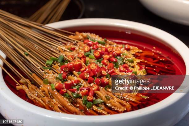 yachang duck intestines skewers in a bowl with spicy oil sauce - szechuan cuisine stockfoto's en -beelden