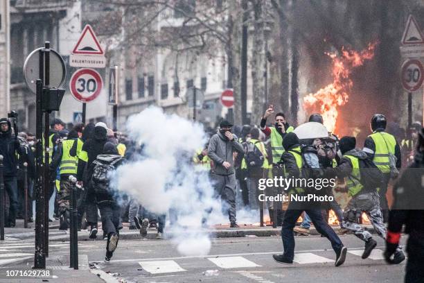 Protesters seen in tear gas smoke and fire in Champ Elysees near Arc De Triomphe during the Yellow Vest demonstration. Clashes and vandalism which...
