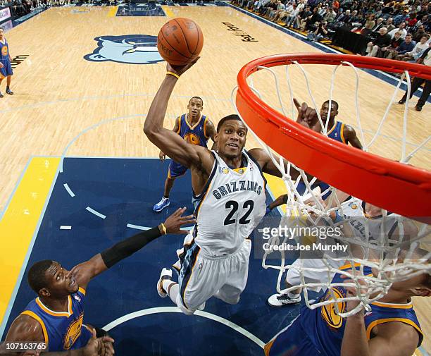Rudy Gay of the Memphis Grizzlies dunks against Andris Biedrins and Jeff Adrien of the Golden State Warriors on November 26, 2010 at FedExForum in...