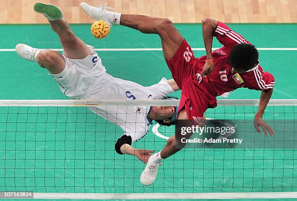 Jun Ho Lee of Korea trys to kick the ball past Aung Zaw Zaw of Myanmar during the Sepaktakraw Mens Double final between Korea and Myanmar at...