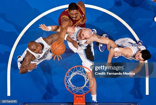 Leon Powe of the Cleveland Cavaliers reaches for a rebound over Marcin Gortat and Quentin Richardson of the Orlando Magic on November 26, 2010 at the...