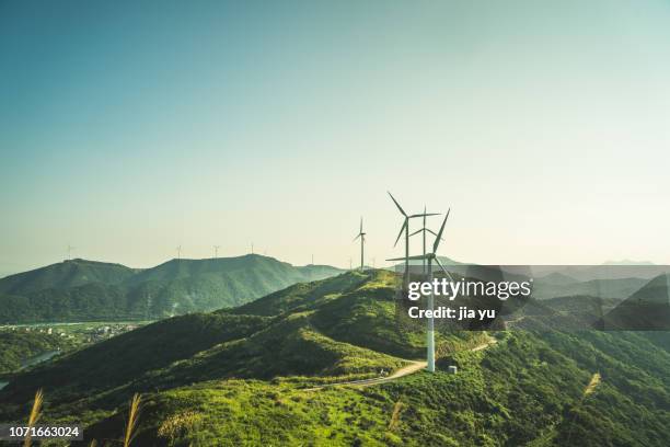 large group of wind turbines on the mountain near by sea - business air travel photos et images de collection