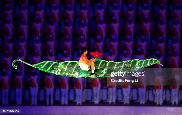 Boy travels through the air to turn off the flame during the Closing Ceremony at Haixinsha Square on day fifteen of the 16th Asian Games Guangzhou...