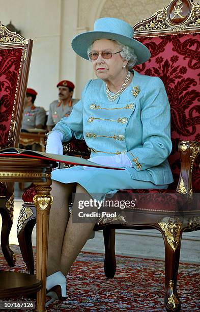 Queen Elizabeth II sits as she watches an equestrian event and horse racing, at the Royal Horse Racing Club ON nOVEMBER 27, 2010 in Seeb Oman. The...