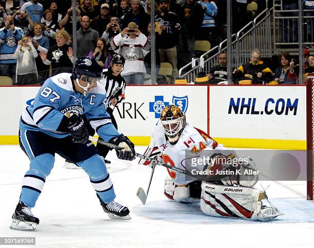 Miikka Kiprusoff of the Calgary Flames makes a glove save on Sidney Crosby of the Pittsburgh Penguins on a penalty shot at Consol Energy Center on...
