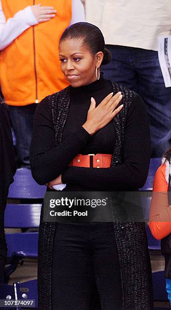 First lady Michelle Obama stands for the National Anthem during a college basketball game at Howard University November 27, 2010 in Washington, DC....