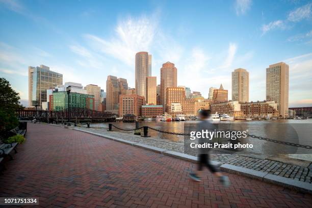 people running near boston harbor and financial district at sunrise in boston, massachusetts, usa. - boston massachusetts bildbanksfoton och bilder