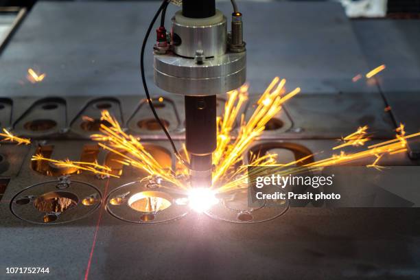 the fiber laser cutting machine cutting the sheet metal plate with the sparking light. hi-technology manufacturing concept. - laser engraving stock pictures, royalty-free photos & images