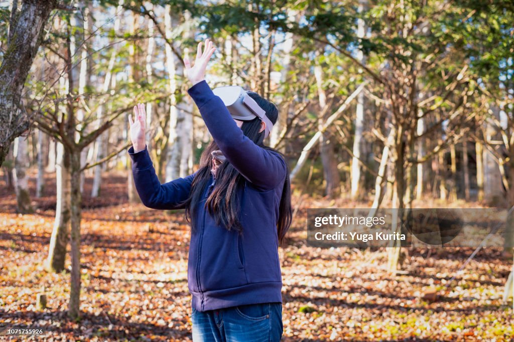 Woman Using a VR Headset in a Forest in Autumn