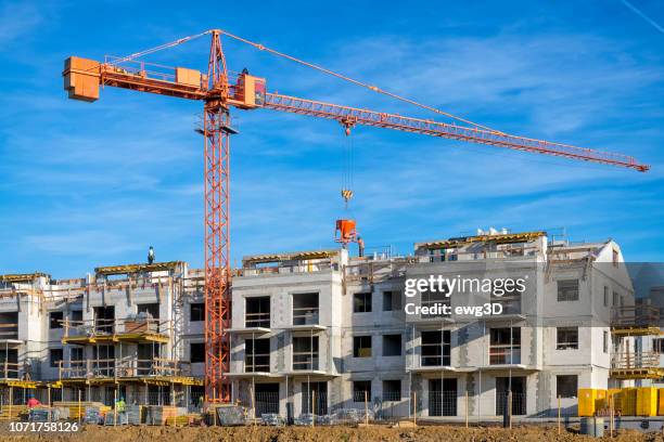 new complex of apartment buildings under construction - crane stock pictures, royalty-free photos & images