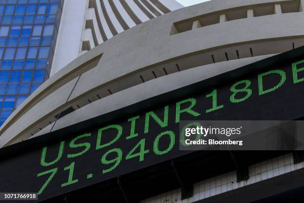 An electronic ticker board indicates U.S dollar to Indian rupee currency exchange rate outside the Bombay Stock Exchange building in Mumbai, India,...