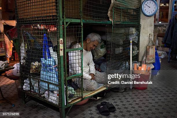 Years old Leung Shu looks out of his cage dwelling on November 27, 2010 in Hong Kong, China. Hong Kong's property prices having soared over the past...