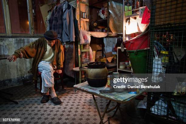 Year old Leung Shu sits beside his cage as he prepares to settle in for the evening on the apartment floor which he now only shares with 4 other...