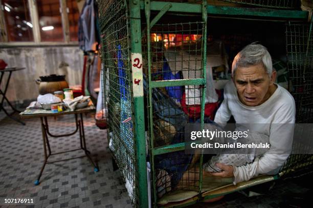 Years old Tam Wing Dik looks out of his cage dwelling on November 27, 2010 in Hong Kong, China. Hong Kong's property prices having soared over the...