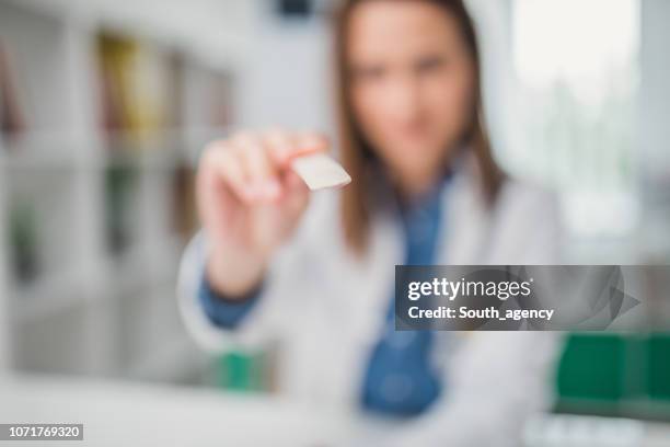 vrouwelijke arts met tong depressor - mensentong stockfoto's en -beelden