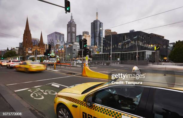 blurred taxi and incidental people near city center. - taxi melbourne stock pictures, royalty-free photos & images
