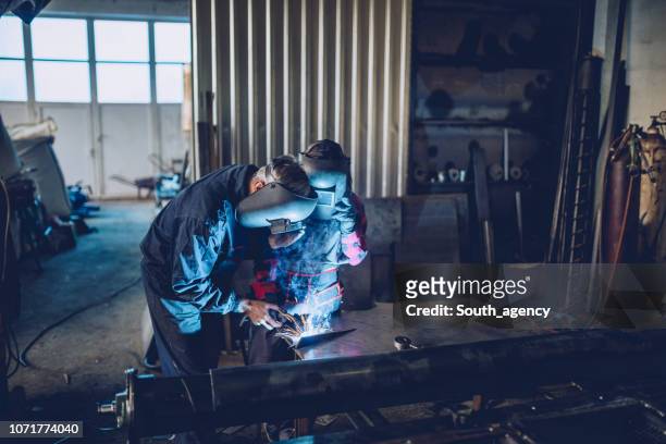 man en vrouw lassen in werkplaats - metal workshop stockfoto's en -beelden