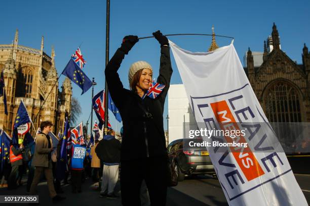 Pro-Brexit campaigner waves a flag with the "Leave means Leave" slogan on outside the Houses of Parliament in London, U.K., on Tuesday, Dec. 11,...