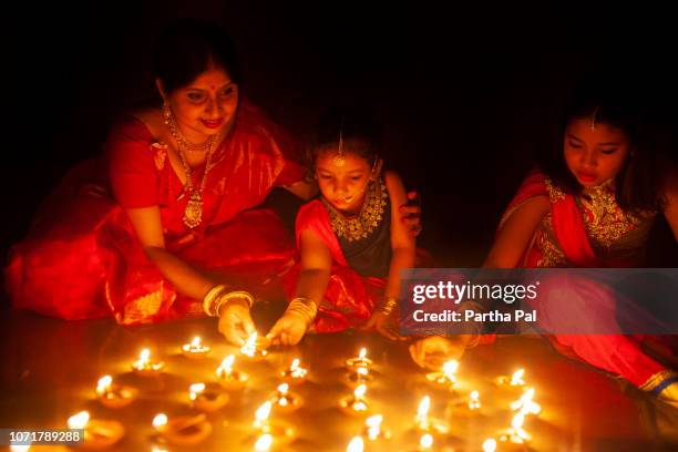 Mother and daughter lighting earthen lamps in Diwali Festival