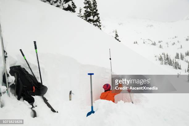 cavando um poço de neve para testar a estabilidade - avalanche - fotografias e filmes do acervo
