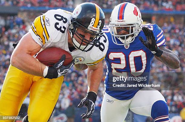 Heath Miller of the Pittsburgh Steelers runs out of bounds with the ball after completing a catch in front of Donte Whitner of the the Buffalo Bills...