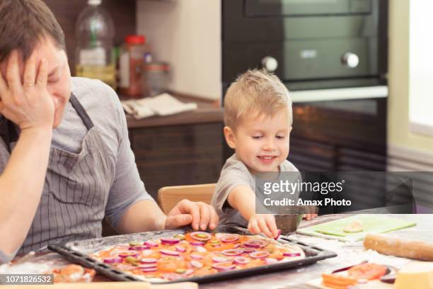 dad and son cooking pizza at home - thick stock pictures, royalty-free photos & images