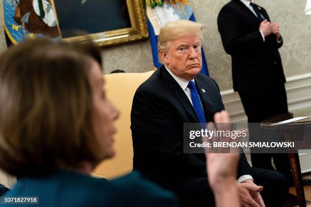 President Donald Trump listens while presumptive Speaker, House Minority Leader Nancy Pelosi makes a statement to the press before a meeting at the...