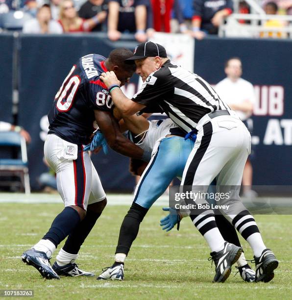 Wide receiver Andre Johnson of the Houston Texans is separated by umpire Garth DeFerlice from cornerback Cortland Finnegan of the Tennessee Titans...