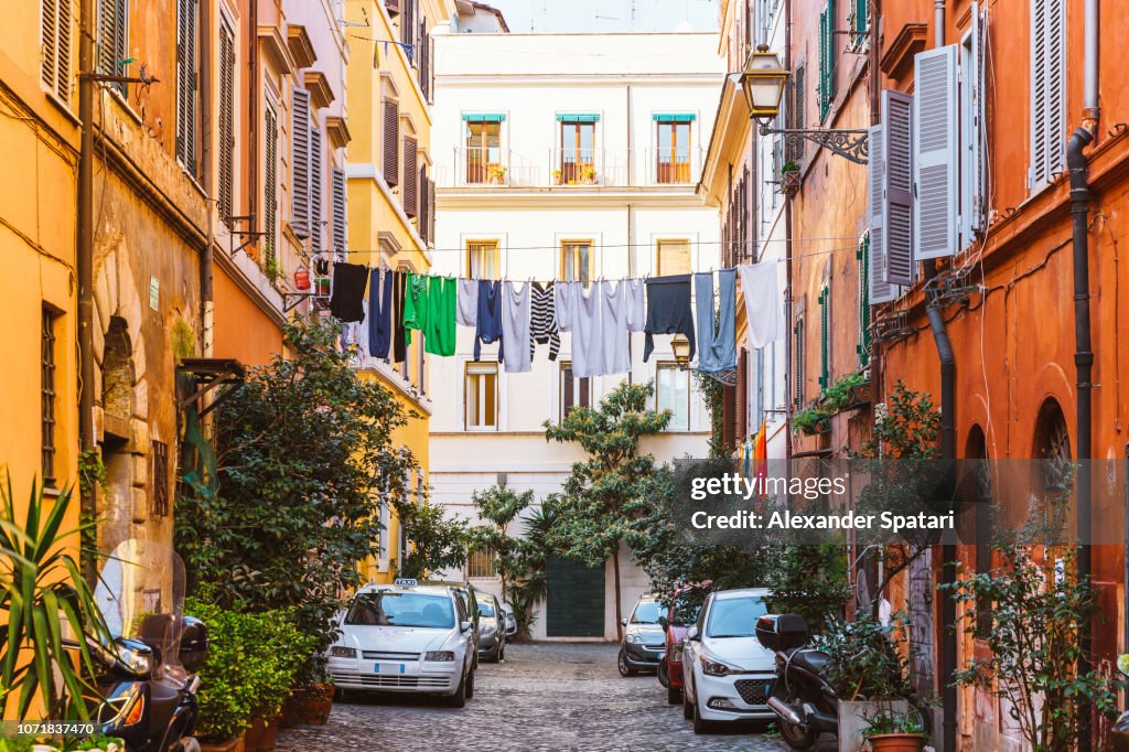 Narrow street in Trastevere with clean clothes on a washing line after laundry, Rome, Italy