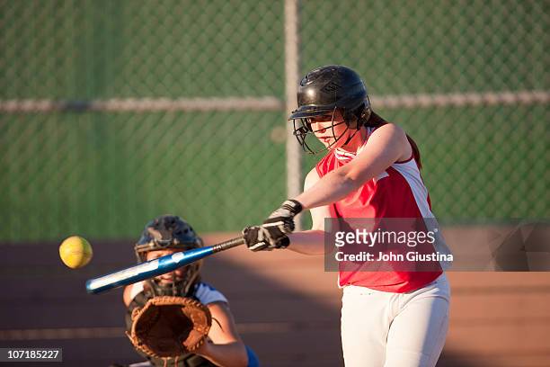 girl's softball player batting. - baseball hit stock pictures, royalty-free photos & images