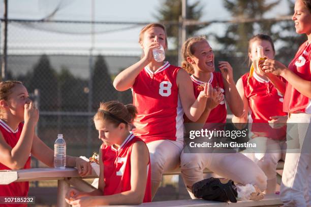 girl's softball team takes a snack break. - softball sport stock-fotos und bilder