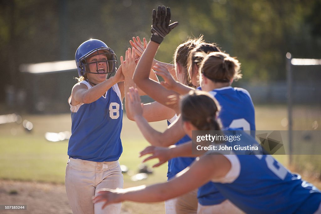 Softball players celebrate.