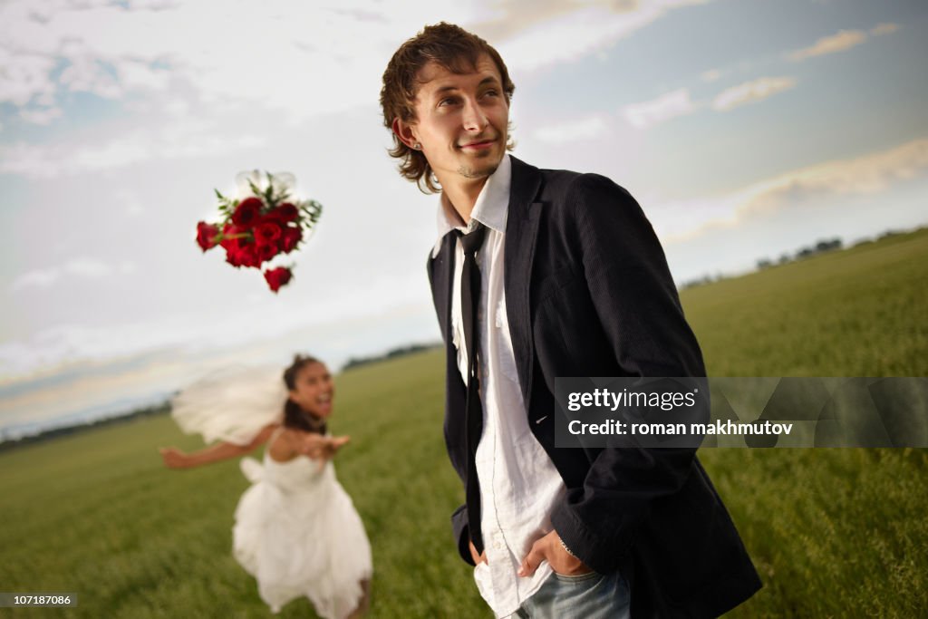 Bride throwing her bouquet to the groom