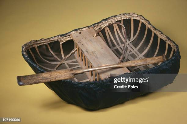 An example of a Teifi coracle, a small lightweight boat traditionally used in Wales, on display in the Exeter maritime museum, Devon, circa 1980.