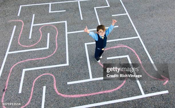 young boy businessman stands in maze. - maze solution stock pictures, royalty-free photos & images