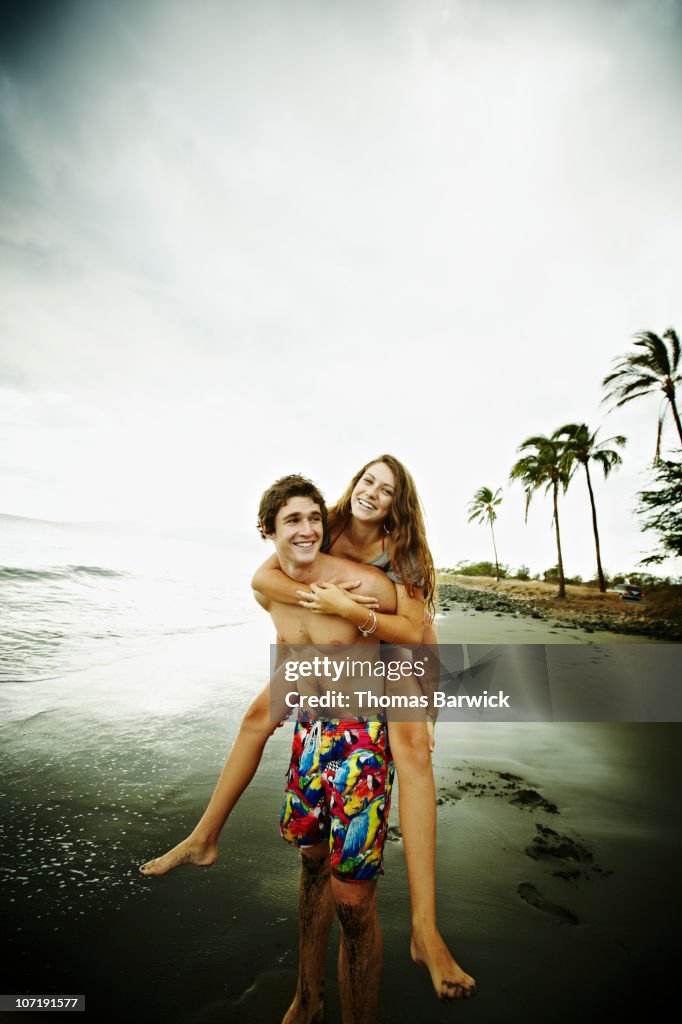 Teenage girl riding on boyfriend's back