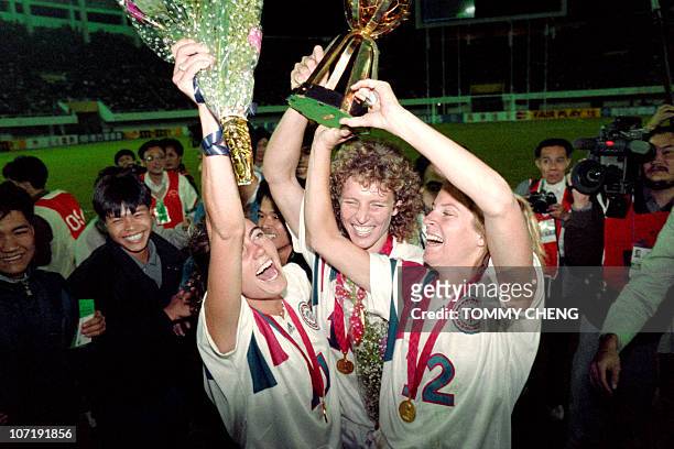 Michelle Akers-Stahl who scored two goals for the US to win the first FIFA World Championship for Women's Football on November 30 holds the trophy...