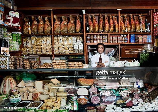 a grocer behind his counter in his shop - gemüseladen stock-fotos und bilder