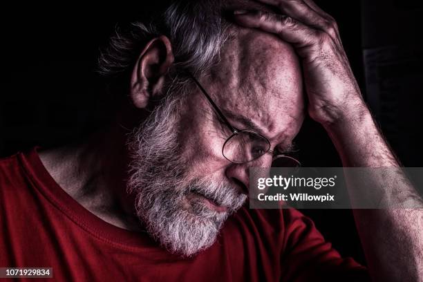 distraught senior adult man holding head - distraught elderly stock pictures, royalty-free photos & images